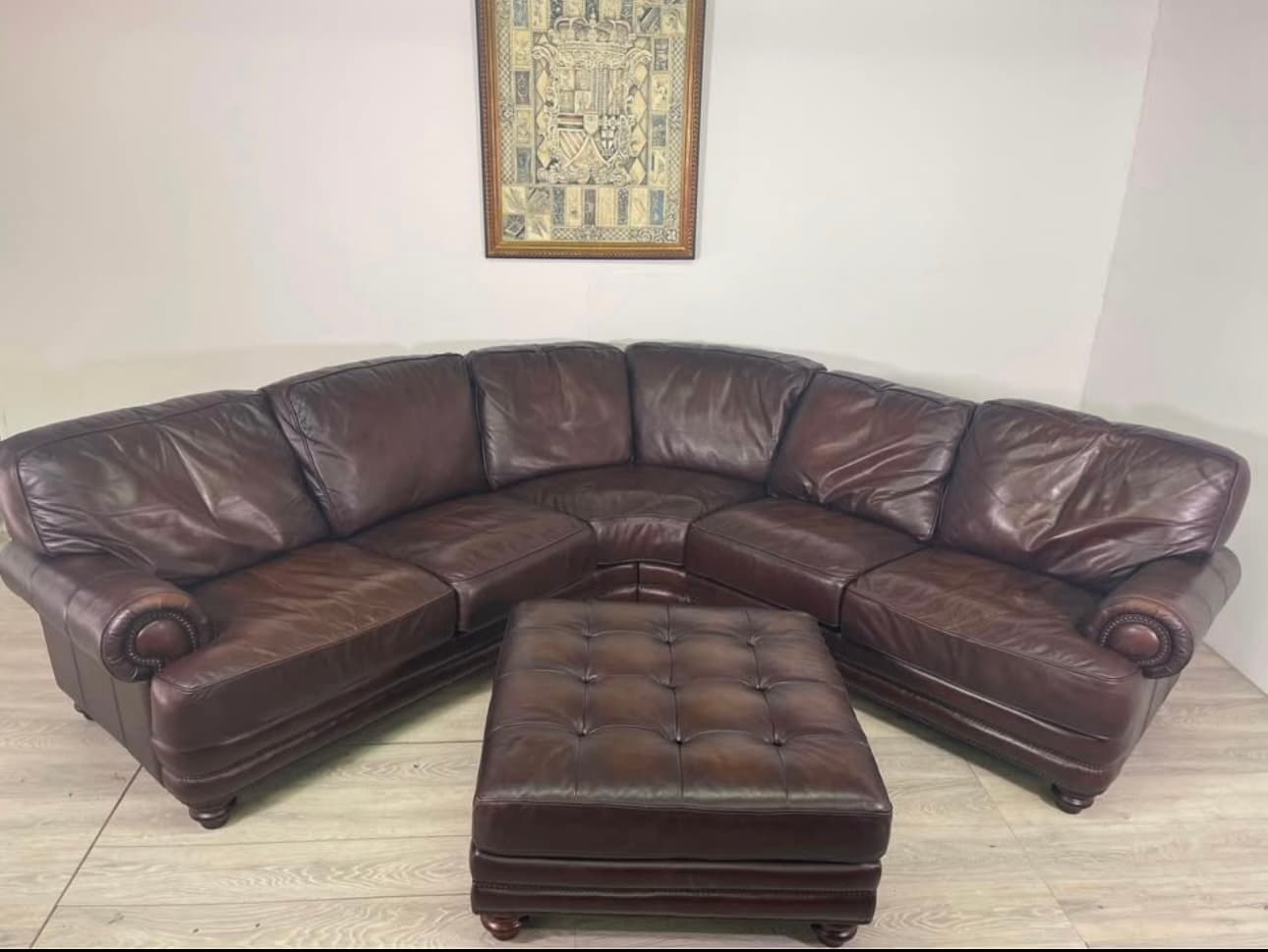 Brown leather curved sectional with ottoman