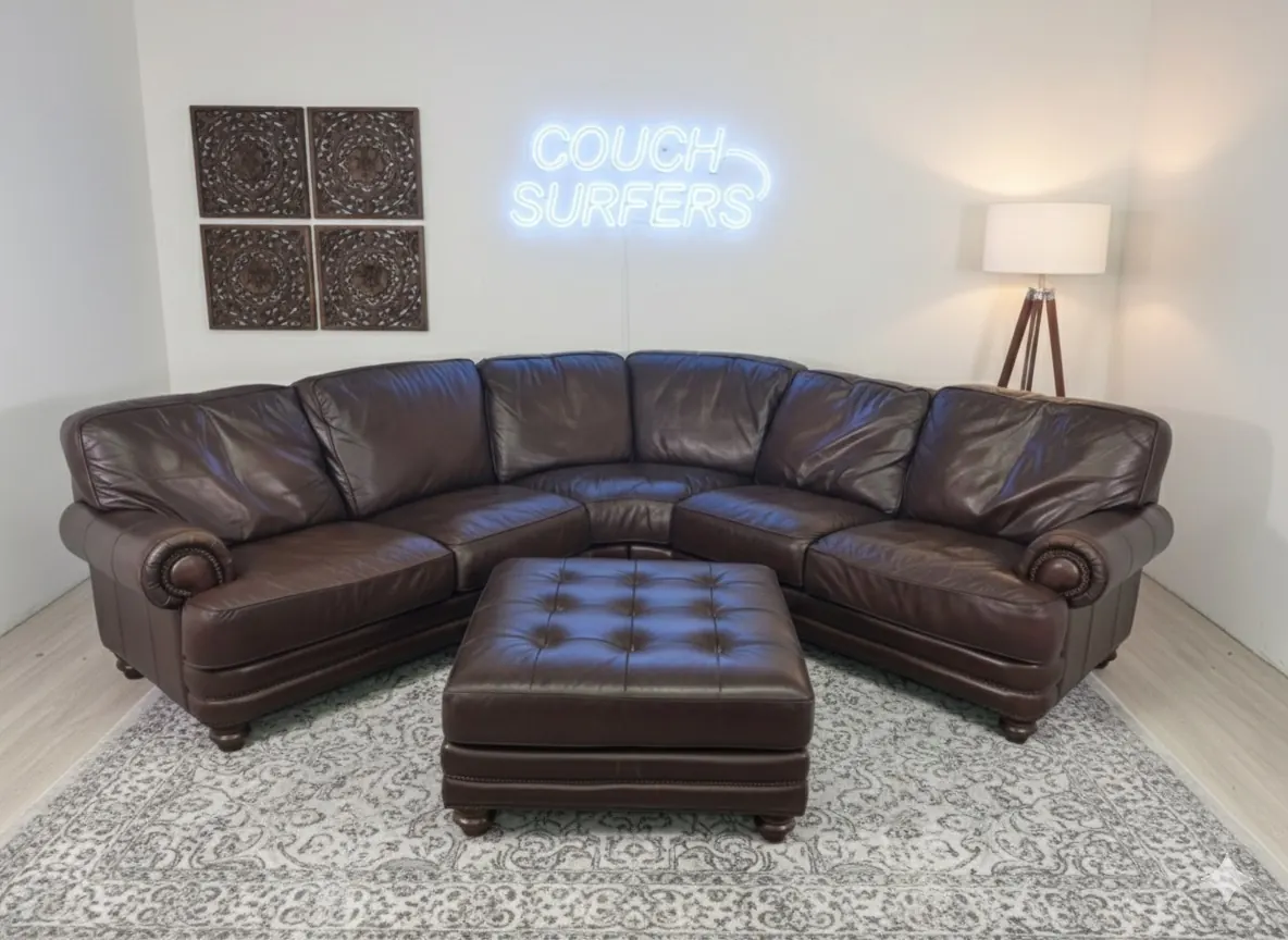 A cleaned brown leather sectional staged under the Couch Surfers neon sign