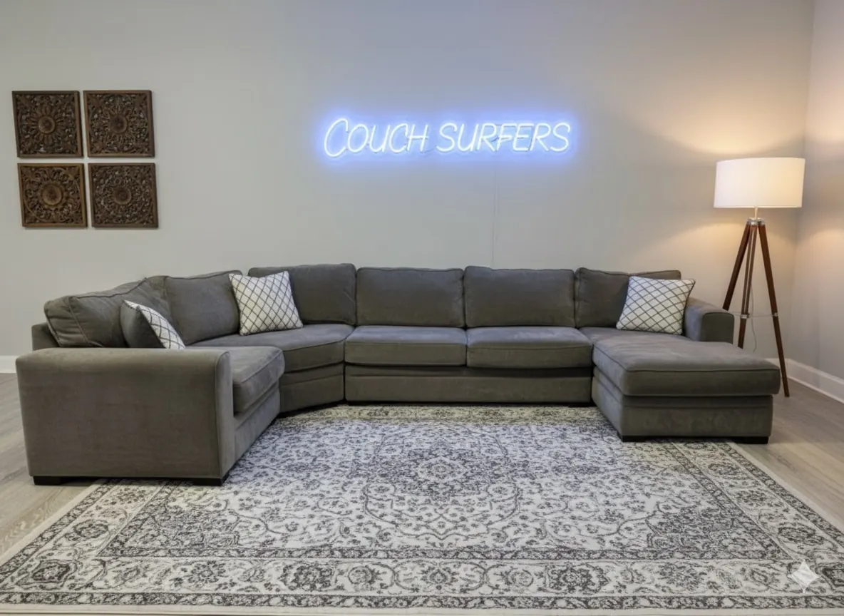 The CouchSurfer staging room with a cleaned gray sectional under the Couch Surfers neon sign